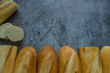 Fresh baked baguettes on a grey background with space for copying