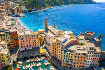 Aerial view of Camogli. Panorama of Castle della Dragonara and Basilica Santa Maria Assunta. Colorful buildings near the ligurian sea beach. View from above on boats and yachts moored in marina