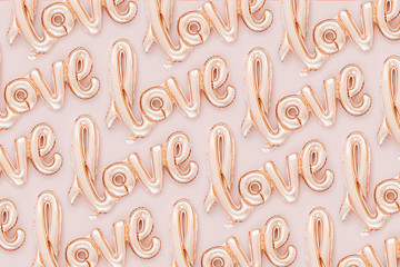 Pale pink Foil Balloons in the shape of the word "Love" on pastel background. Love concept. Holiday, celebration. Valentine's Day or wedding/bachelorette party decoration.