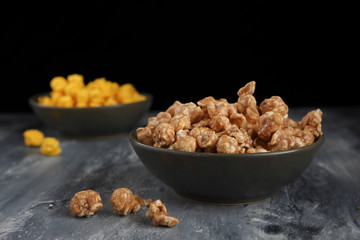Caramel corn in a shallow green bowl.