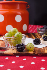 Rural still life with fruits and berries. Close-up, fresh ripe cherry-plums and blackberries.