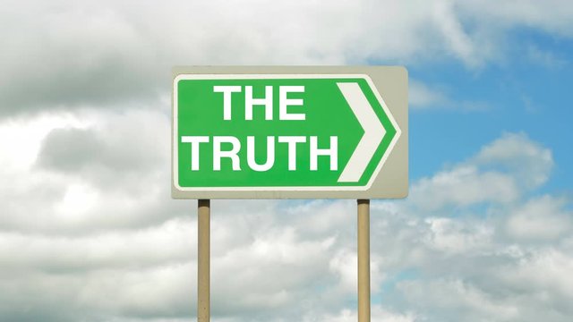 Pointing the way to the truth on a road sign with timelapse white clouds in the background. Taking the road to the truth.