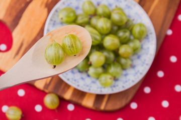 Close-up cherry-plums in a rustic spoon. Plate with heap of cherry-plums, top view.