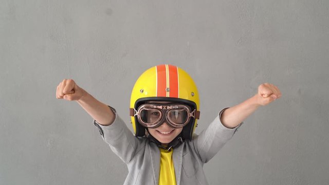 Happy child wearing racing helmet and goggles. 4K
