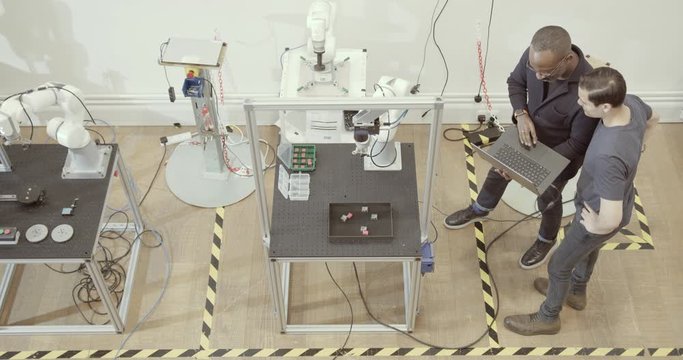 Overhead shot of team programming a robotic arm