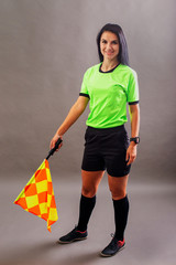 Beautiful Soccer Referee with flag in hand looking at camera and smile
