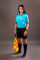 Beautiful Soccer Referee with flag in hand looking at camera and smile