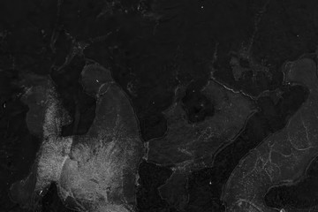 Schwarz-weiß Bild einer gefrorenen Eisfläche im Winter, Pfütze