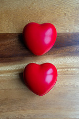 two red hearts on a wooden background 