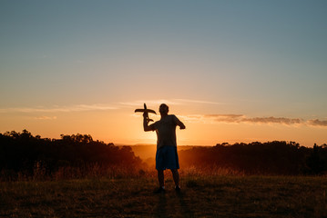 Fototapeta premium man with airplane at sunset