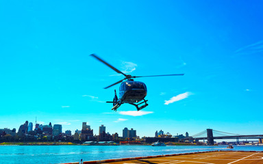 Helicopter at Manhattan bridge across East River, New York, USA. It is among the oldest in the United States of America. NYC, US. Skyline and cityscape. American construction