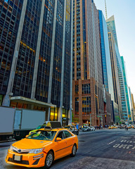 Yellow taxi on road. Street view in Financial District of Lower Manhattan, New York of USA. Skyline...