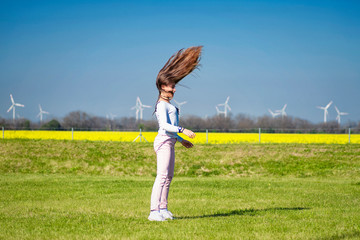 Girl on the nature does acrobatic stunts.A young girl jumping on the grass, a girl in the nature of...