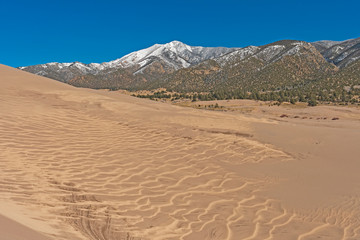 Fototapeta na wymiar Sand Patterns and Snowy Peaks