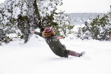Young man slipped and lost his balance during a walk at forest in winter. Freeze frame while slide down to the snow. Falling on snow in winter.