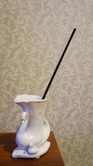 Smoldering Incense Stick in a Swan Cup