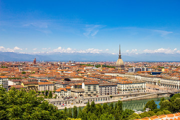 Aerial PAnoramic summer view on Turin skyline, with the city center, Po river, Mole Antonelliana, modern skyscrapers and other landmark seen from viewpoint the Monte dei Cappuccini on snowy alps Italy