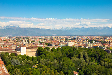 Fototapeta na wymiar Aerial PAnoramic summer view on Turin skyline, with the city center, Po river, Mole Antonelliana, modern skyscrapers and other landmark seen from viewpoint the Monte dei Cappuccini on snowy alps Italy