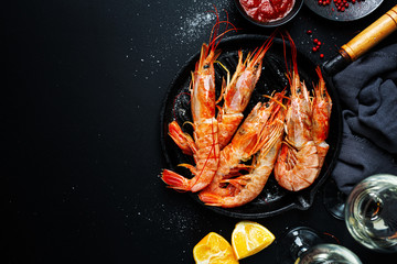 Uncooked giant shrimps on dark table