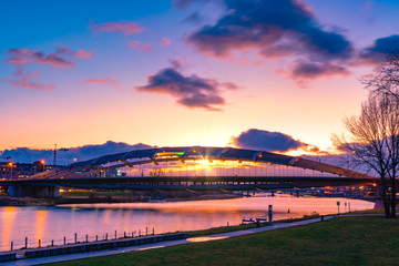 Suspension bridge Kotlarski over the Vistula River in Cracow (Krakow), Poland, against purple and...