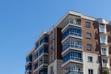 Fototapeta premium an outdoor perspective shoot to corner of a modern building with brown and white colors - clean blue background
