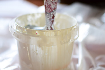 White paint and brush for painting walls. Concept: repair of premises.