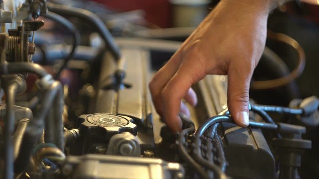 Hands auto mechanic disconnect the motor wires. Hood space. Close-up. Car service. Parse cars. Spare parts.
