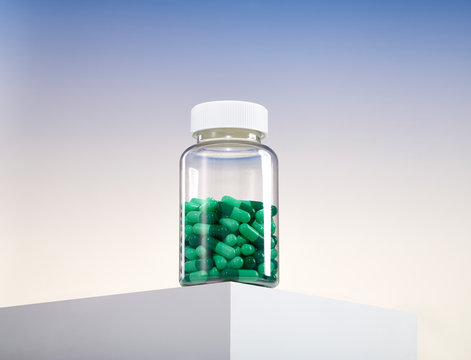Bottle of Multi Color Pills Capsule Medication Vitamins on Counter Table Edge 