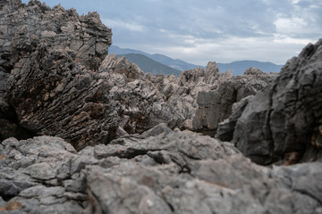Stone cliff with cracks and mountains in the background