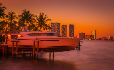 Fototapeta premium sunset orange miami florida beach buildings sea sky palm tropical boat traveling ocean vacation island landscape luxury