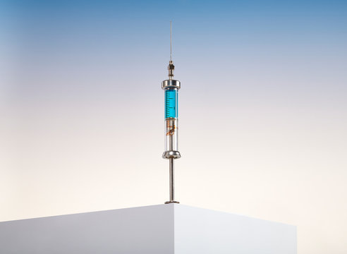 Corona Virus Medical Vaccine Syringe and Needle of Liquid on Counter Table Edge 
