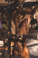 Roasted on the cross Bbq, fire  made on the ground or in a fire pit and surrounded by metal crosses (asadores) that hold the entire carcass of an animal splayed open to receive the heat from the fire