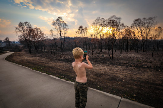 Young Boy Taking Photos Of Aftermath Of The 2019/2020 Bushfire Season In New South Wales, Australia