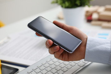 A businessman holds a new smartphone in