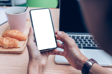 Mockup image blank white screen cell phone.man hand holding texting using mobile on desk at office.background empty space for advertise text.people contact marketing business,technology 