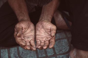 old man beggar begging you for help sitting at dirty slum. concept for poverty or hunger...