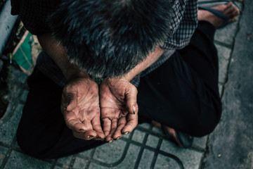 old man beggar begging you for help sitting at dirty slum. concept for poverty or hunger...