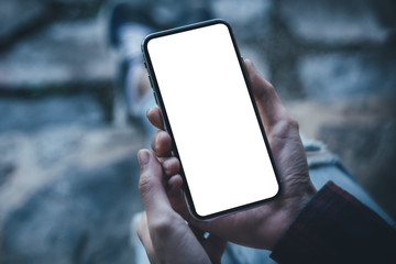 Mockup image blank white screen cell phone.man hand holding texting using mobile at coffee shop.background empty space for advertise text.people contact marketing business,technology 
