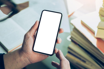Mockup image blank white screen cell phone.man hand holding texting using mobile on desk at coffee shop.background empty space for advertise text.people contact marketing business,technology 