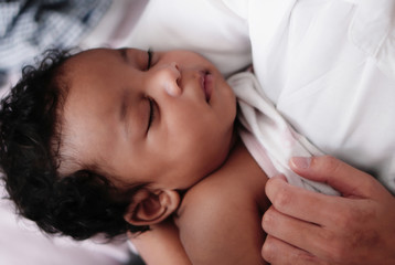portrait of sleeping african american baby girl with mother
