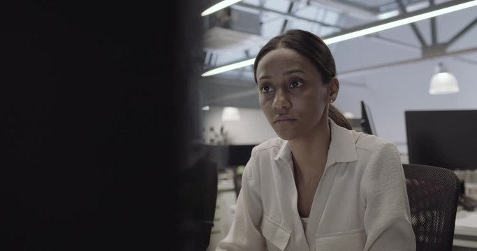 Hispanic businesswoman working on desktop computer