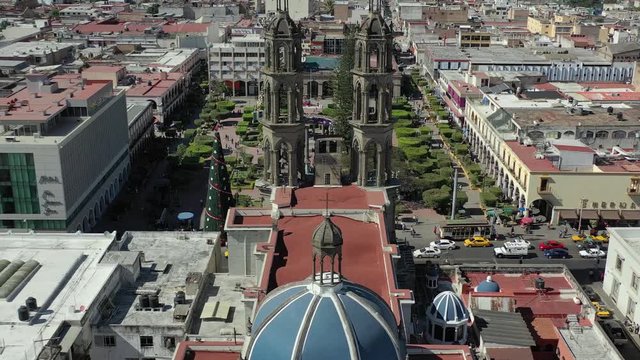 Aerial view of Tepic Cathedral and main square Plaza principal in Tepic capital city of Nayarit in Mexico. Drone tilt down movement. 