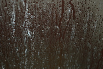 The surface of the glass in the bathroom with water droplets