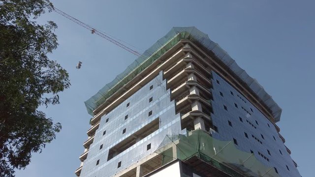 High crane works on building construction site in a city in India - concrete building with advanced building technology
