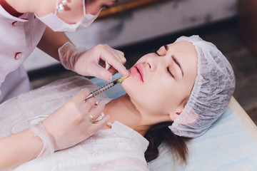 woman receiving a injection in her lips, close up.
