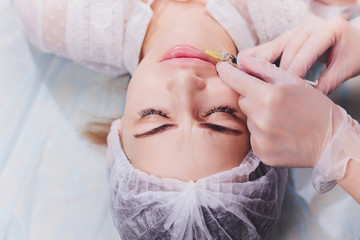 woman receiving a injection in her lips, close up.