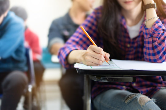high school,university student study.hands holding pencil writing paper answer sheet.sitting lecture chair taking final exam attending in examination classroom.concept scholarship for education abroad