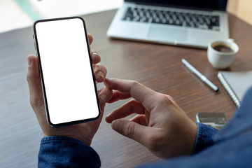 Mockup image blank white screen cell phone.man hand holding texting using mobile on desk at office.background empty space for advertise text.people contact marketing business,technology 