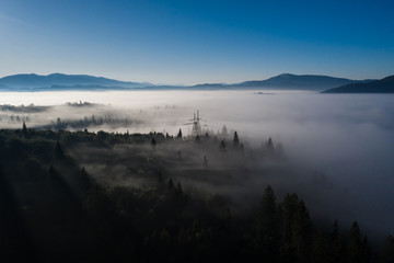 Aerial view of colorful mixed forest shrouded in morning fog on a beautiful autumn day