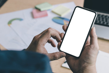 Mockup image blank white screen cell phone.man hand holding texting using mobile on desk at office.background empty space for advertise text.people contact marketing business,technology 